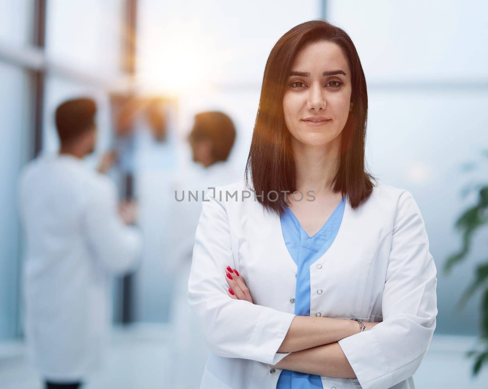 Image of confident female doctor, intern with medical robe, looking confident at camera