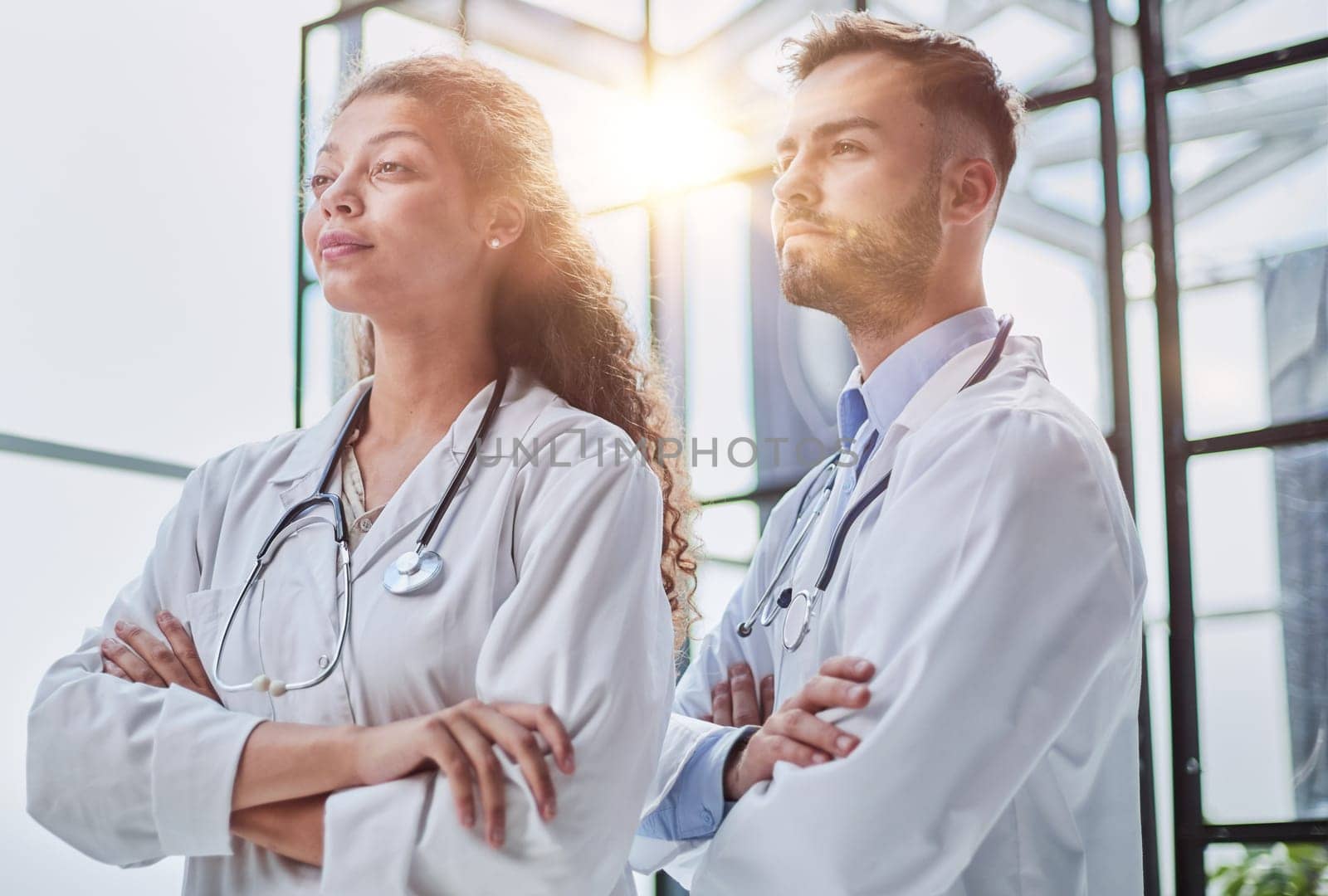 Young male and female dentists look into the distance in a hospital room