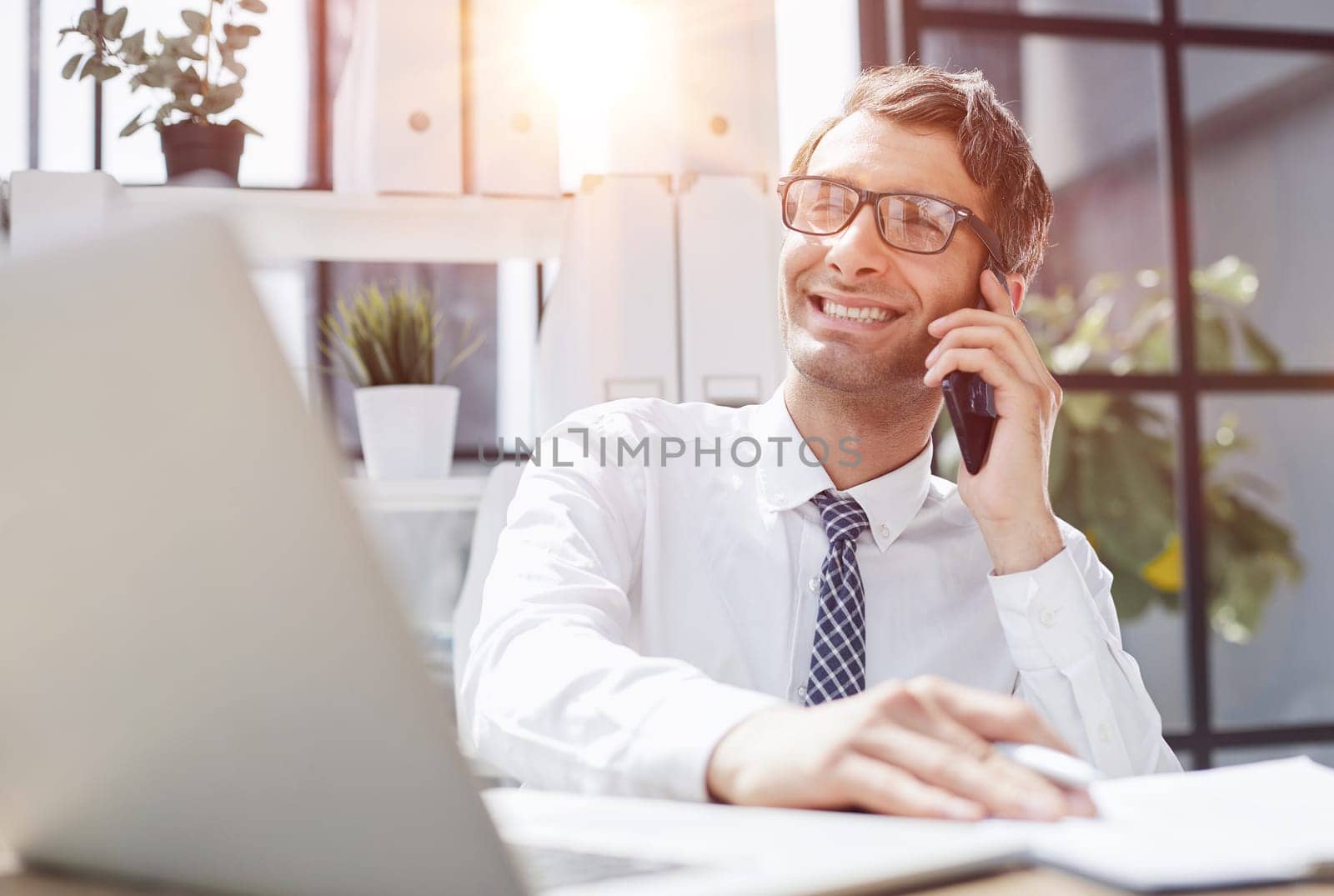 Man accountant or business lawyer talking on smartphone with finance paperwork at workplace