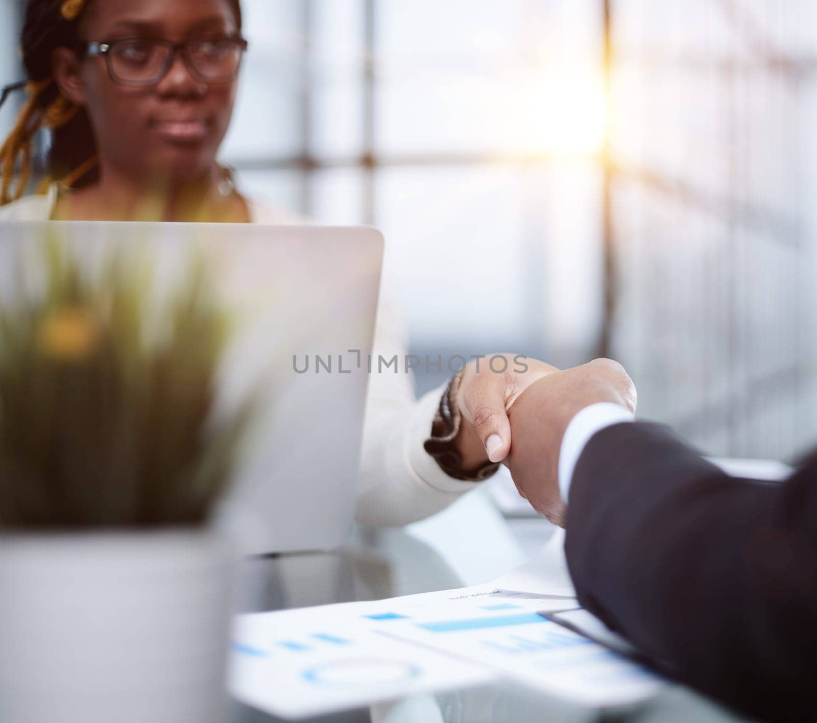 two confident business men shaking hands at the office table