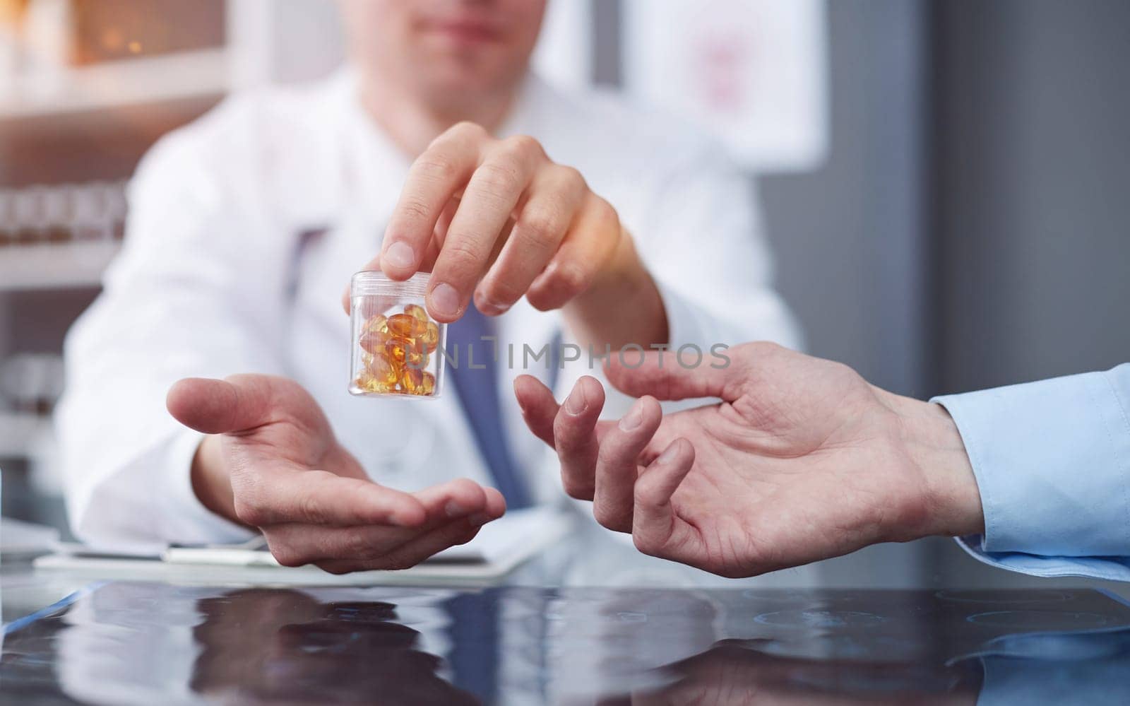 medicine, healthcare and people concept - doctor giving pills to male patient at medical office in hospital