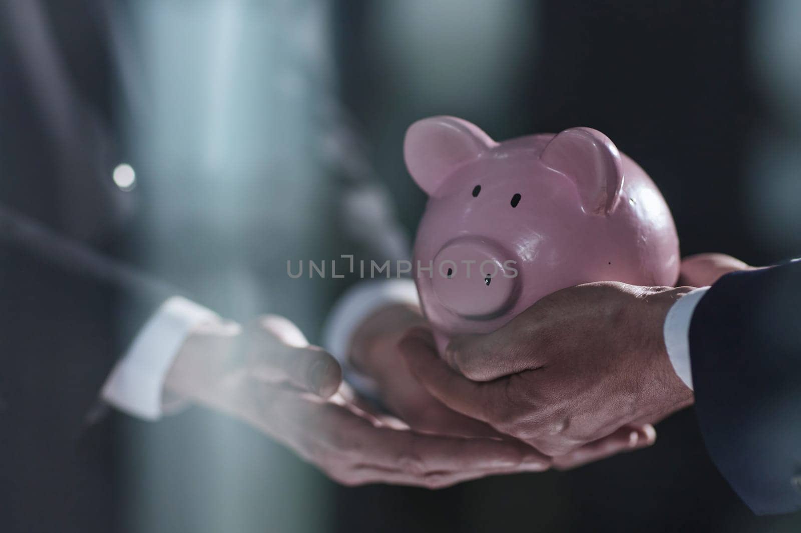 A businessman gives you a piggy bank isolated on a black background. by Prosto