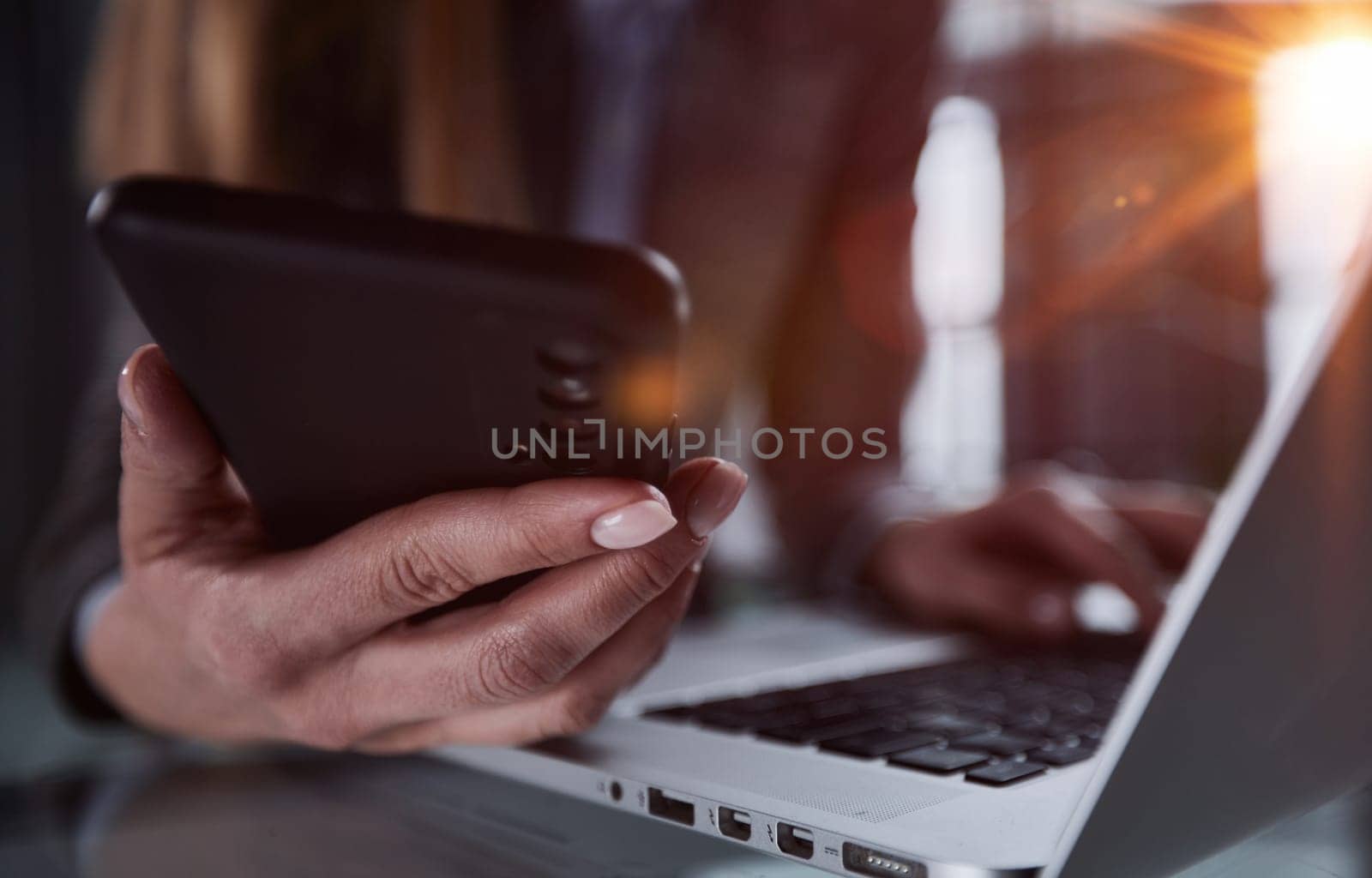 male hands hold a smartphone and use it for online shopping while looking at a laptop