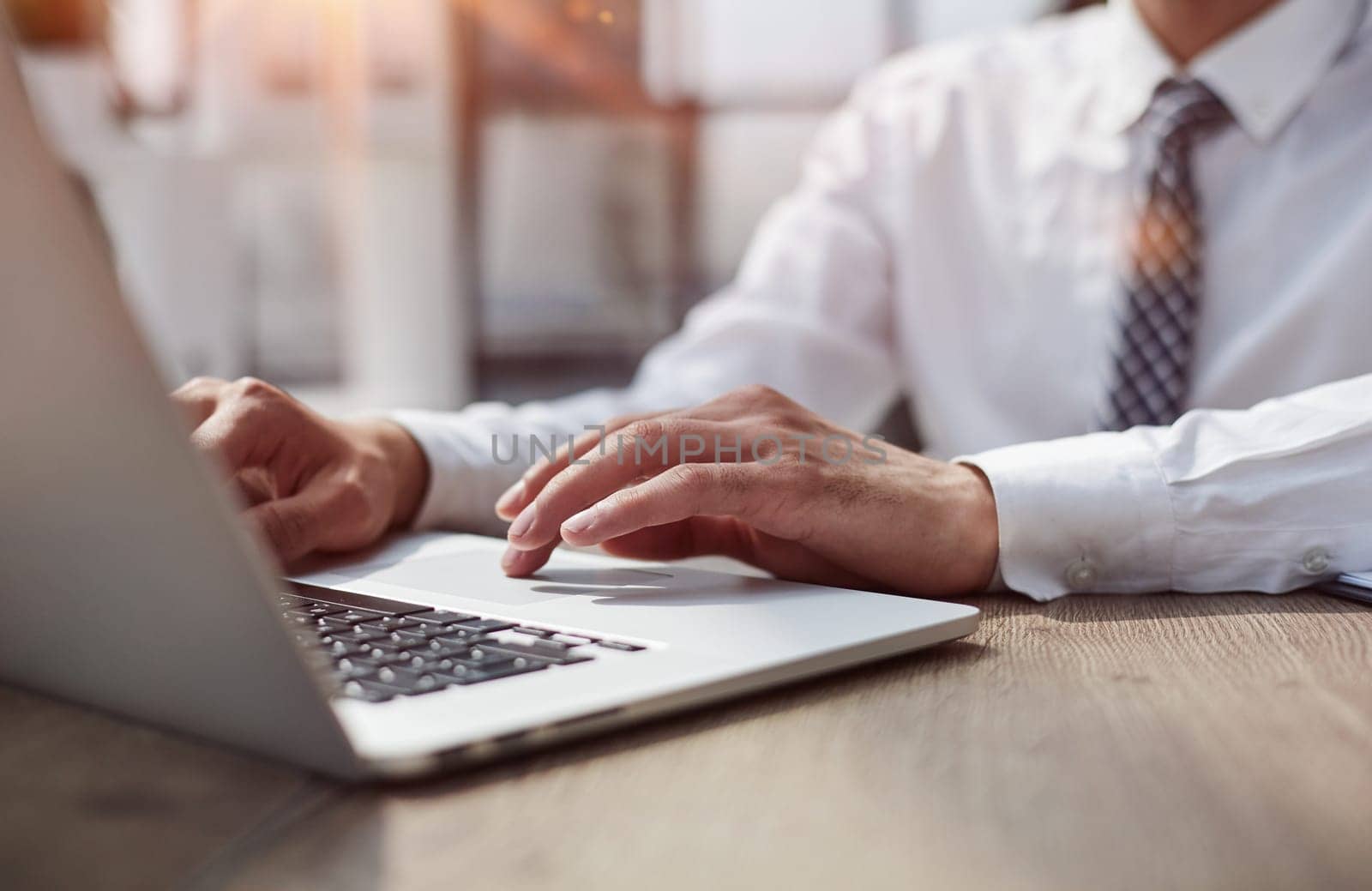 Close-up of a business person's hands on a laptop.