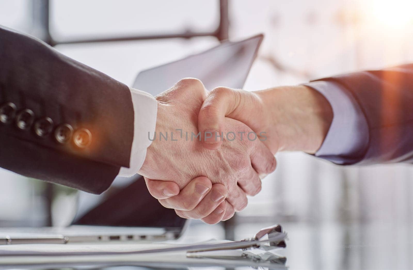close up.the financial partners shaking hands over a Desk by Prosto
