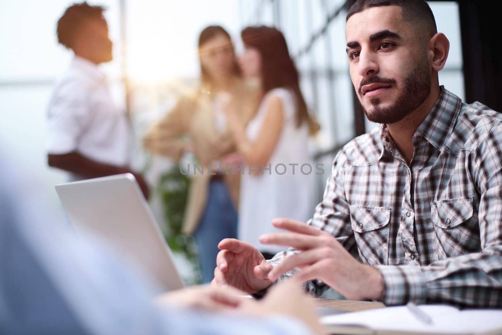 Interview. Young adult caucasian male, hiring manager, sits at a desk in a modern office