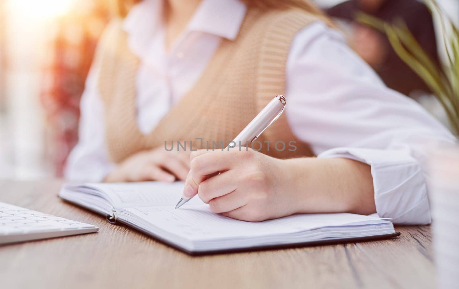 Image beautiful woman writing down notes while sitting at table in office