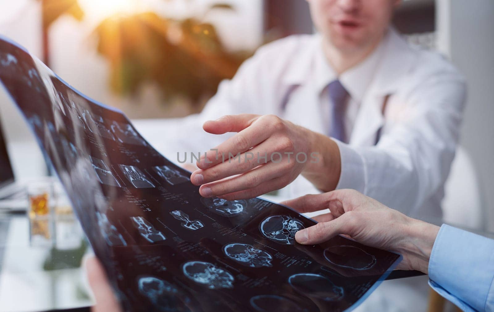 Young man looking at one of x-ray results being shown by his doctor