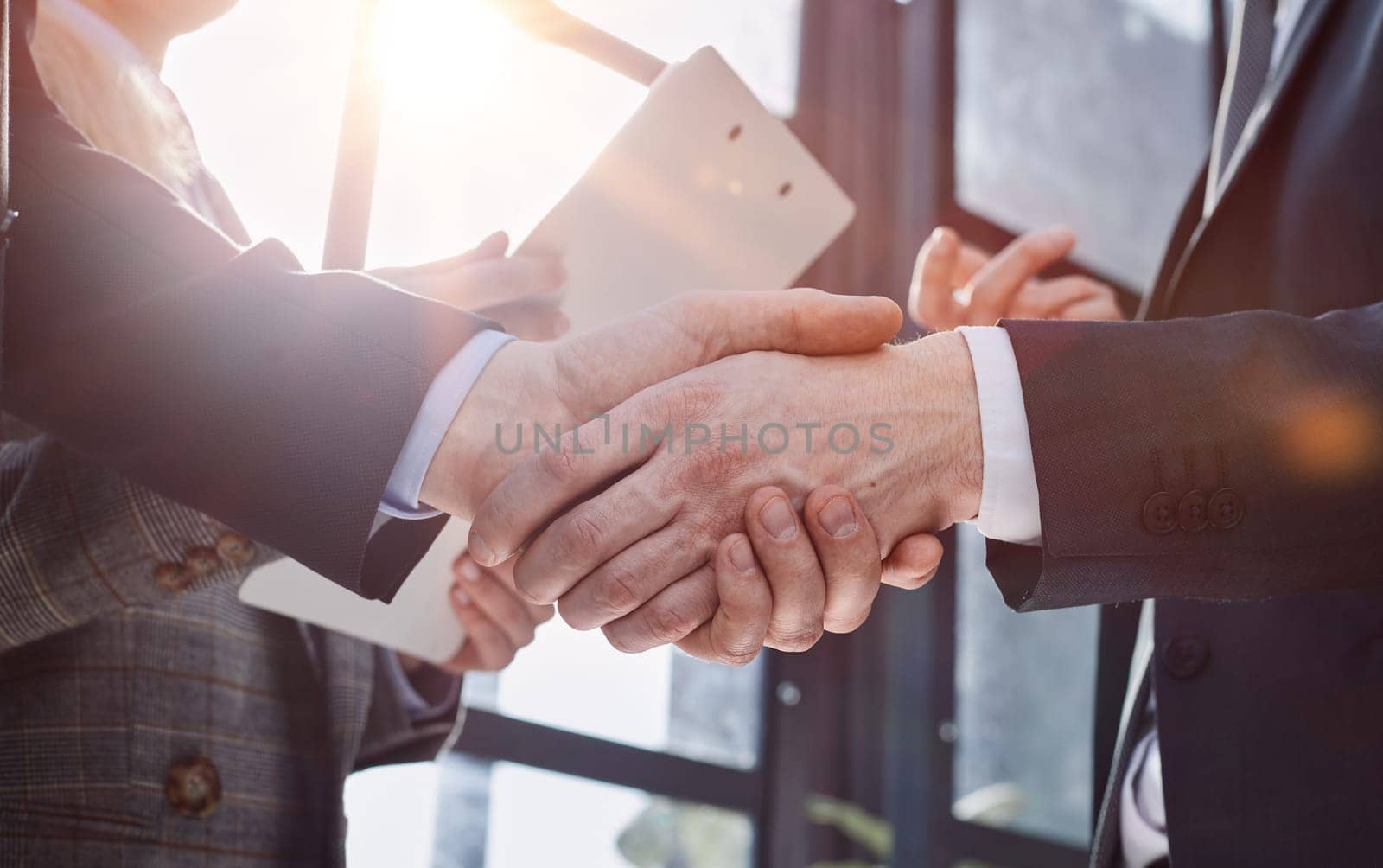businessman shaking hands partnership deal business while standing indoors in the office