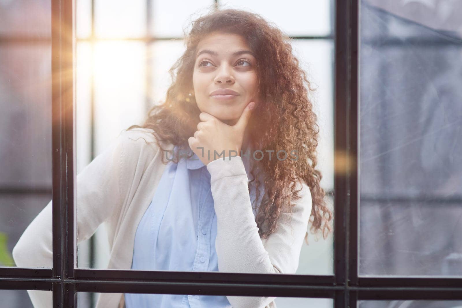 from behind the glass. young business woman thinking about something