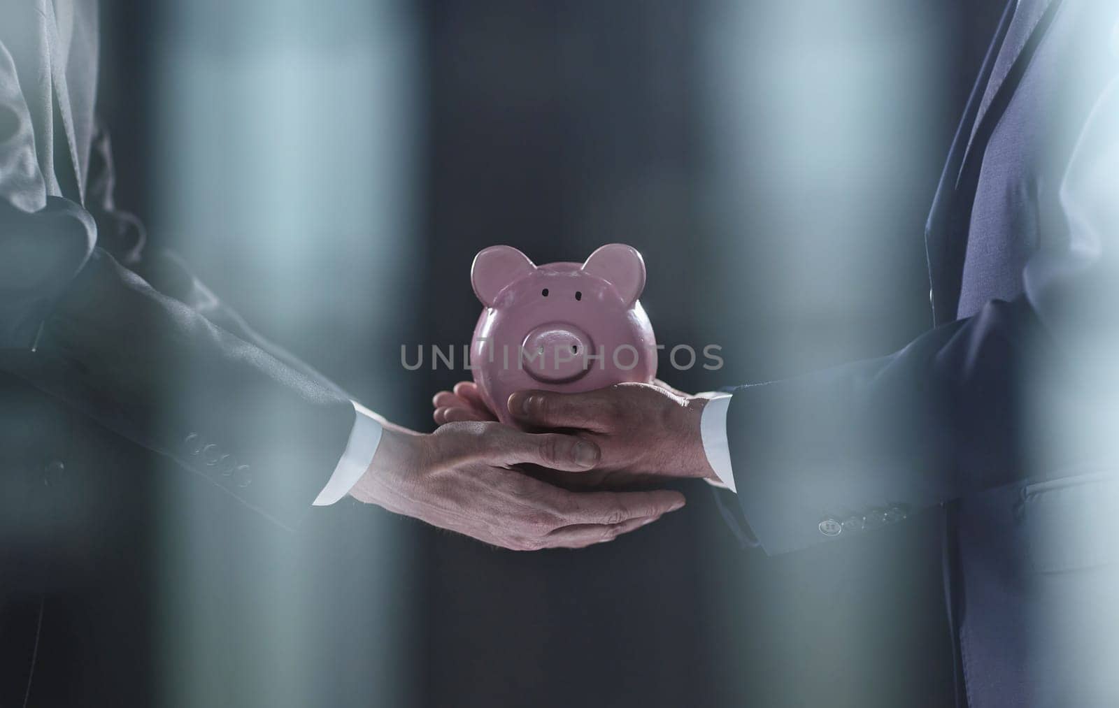 A businessman gives you a piggy bank isolated on a black background. banking