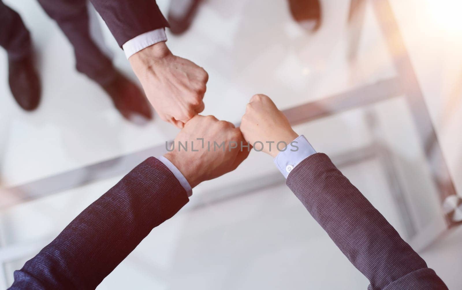A group of successful businesspeople making fist bump together to cheer up, support and making a team spirit in the meeting by Prosto
