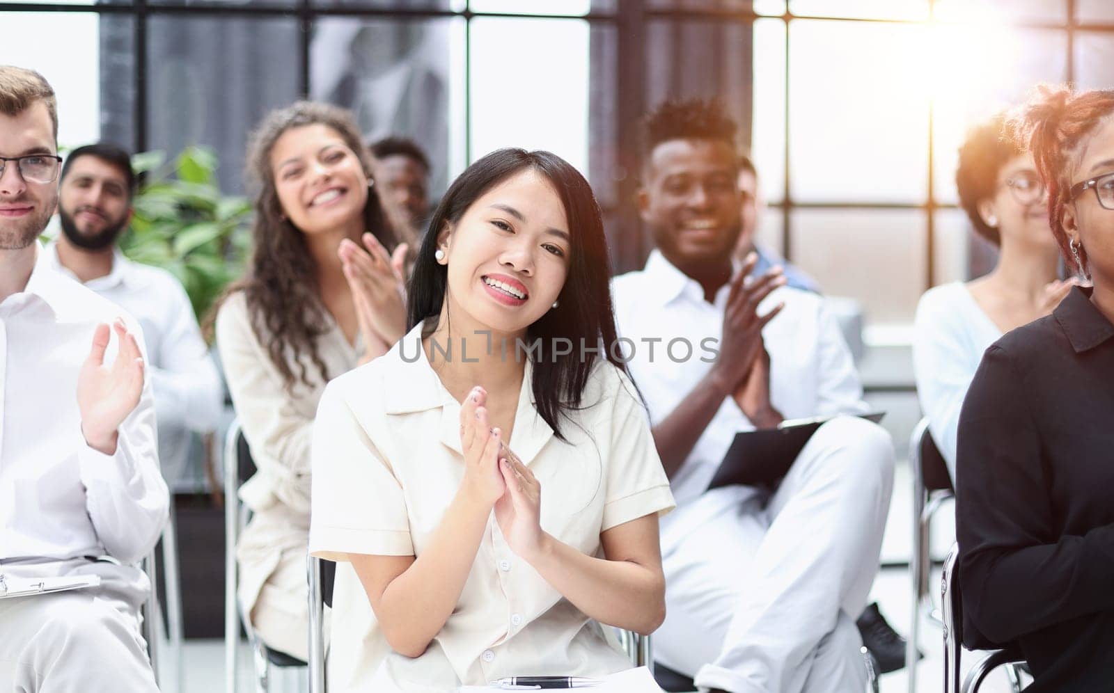 businesswoman applauding during seminar near interracial colleagues