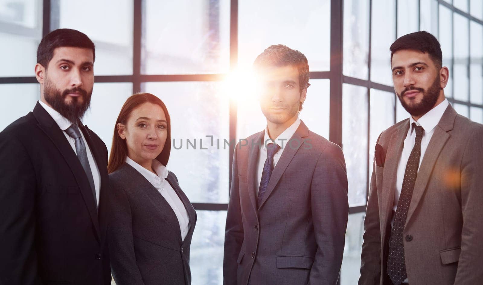 Businessmen with brunette in group posing in office lobby