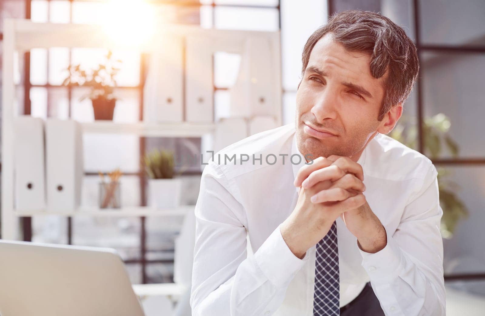Image of successful 30s businessman thinking and holding index finger near forehead in office
