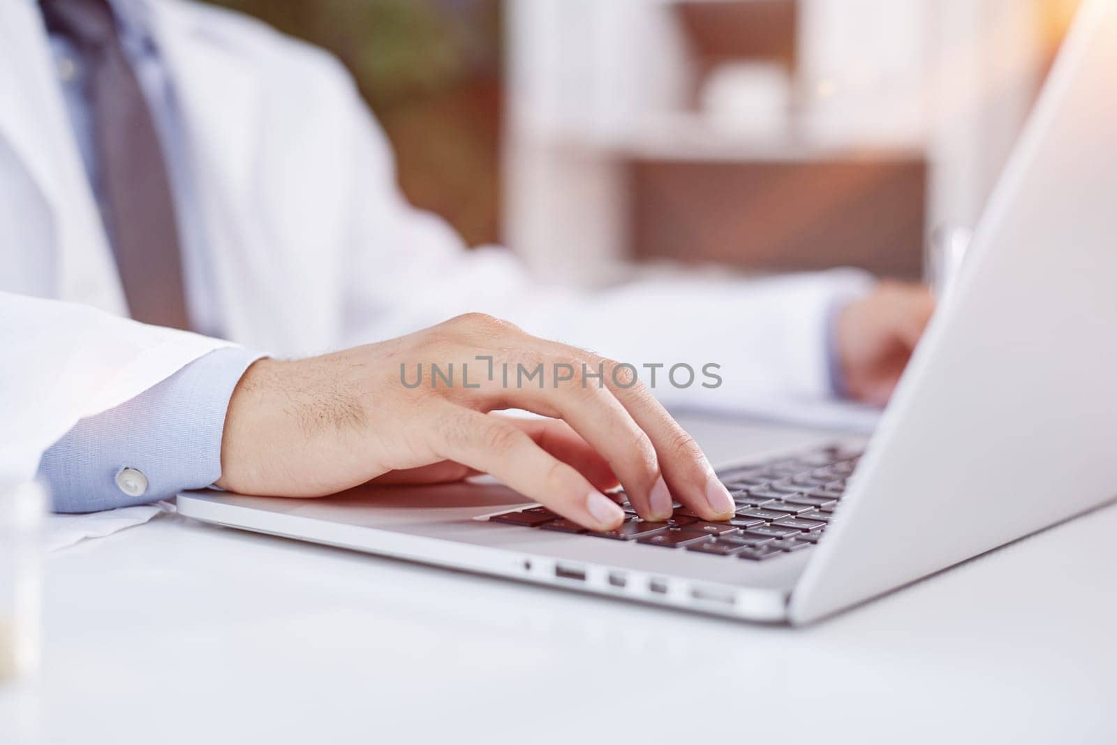 Typing on computer keyboard, doctor using modern technology at work