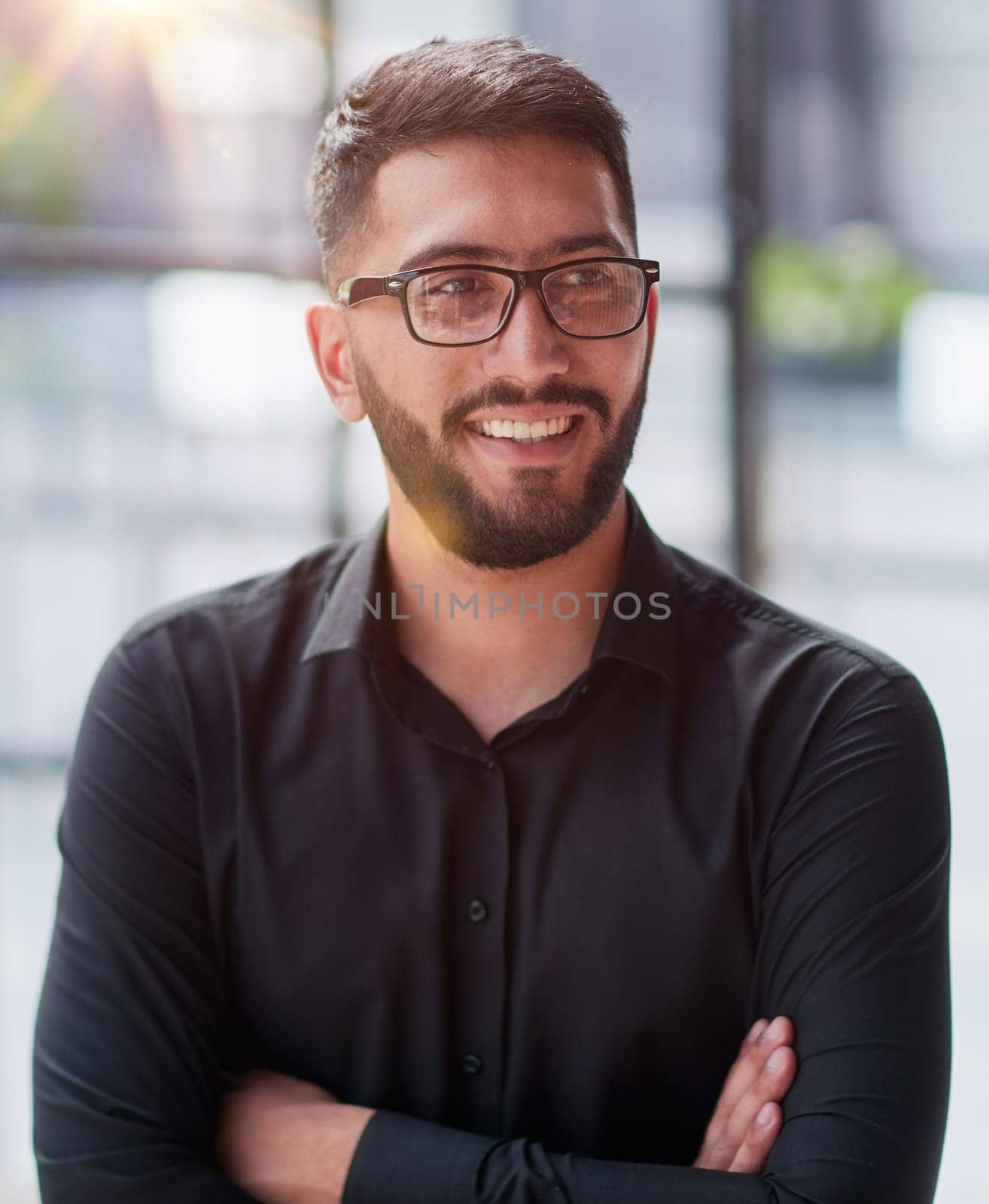 Businessman portrait. Happy confident young businessman standing , smiling, looking at camera.