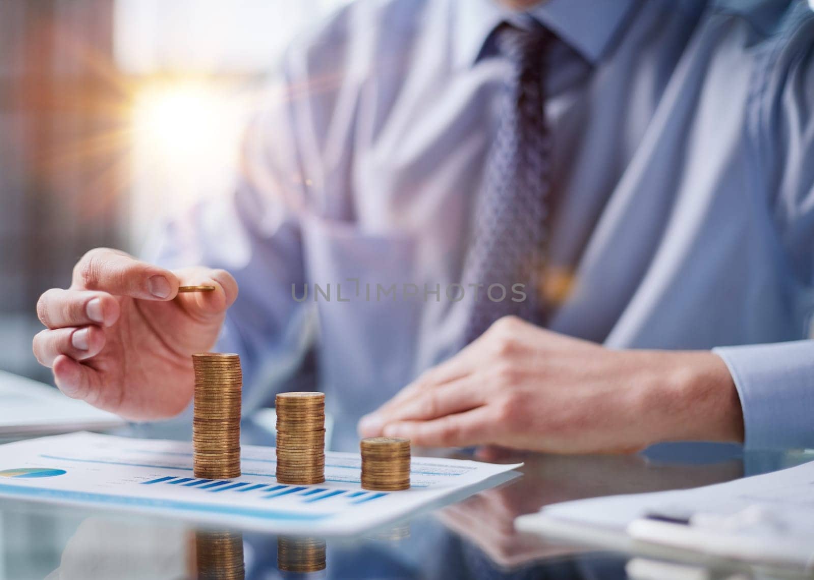 Business, Money, Finance, Secure and Saving Concept. Close up of man hand holding and put a coin to stack of coins table.
