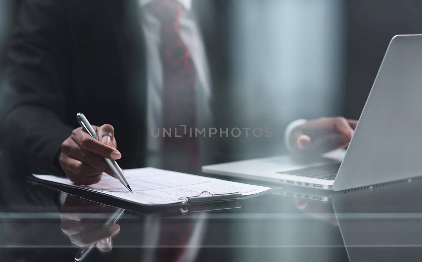 uses a laptop on a wooden table in a dark room. by Prosto