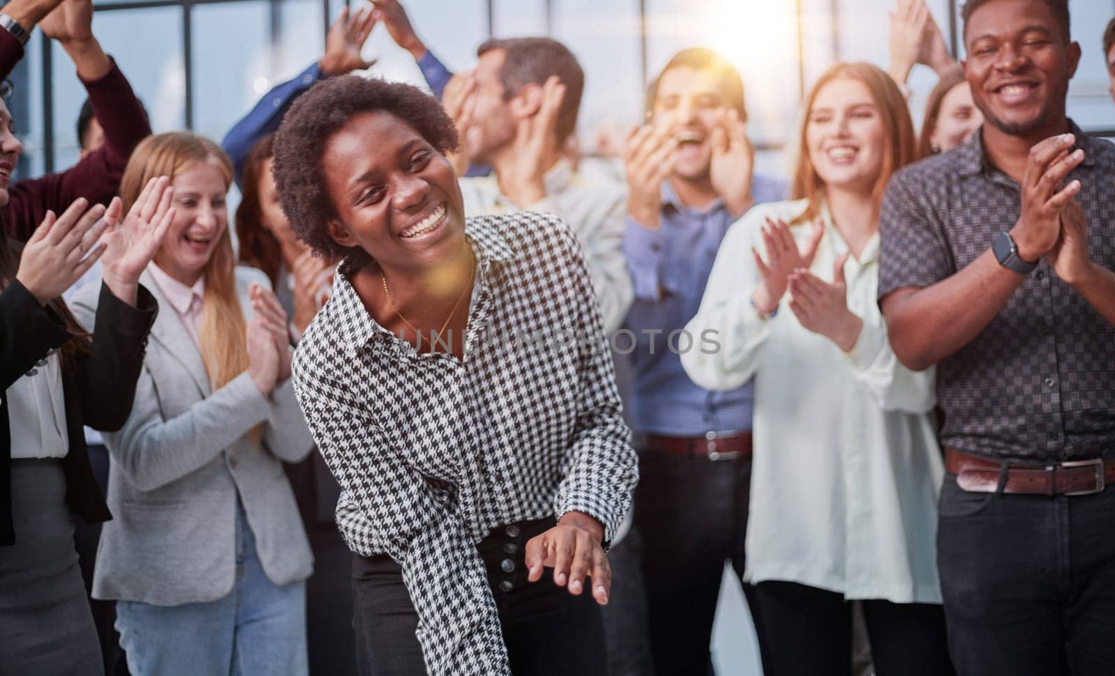 Smiling multiethnic colleagues celebrating common business success or victory in the office.