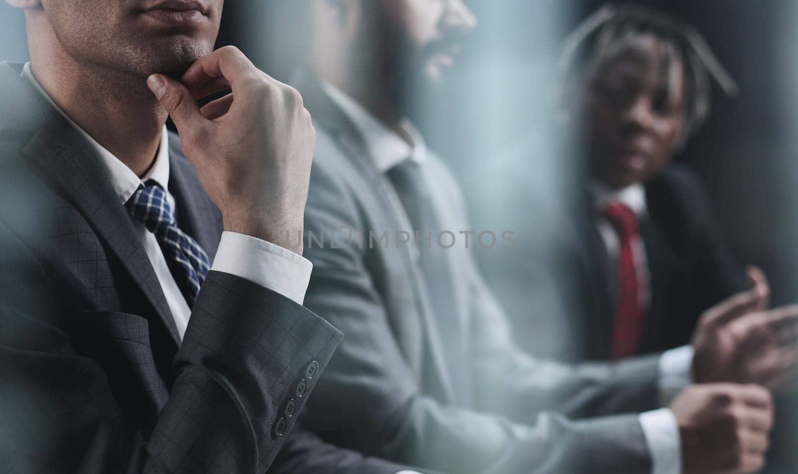 Pensive employee in the office on the background of his colleagues.