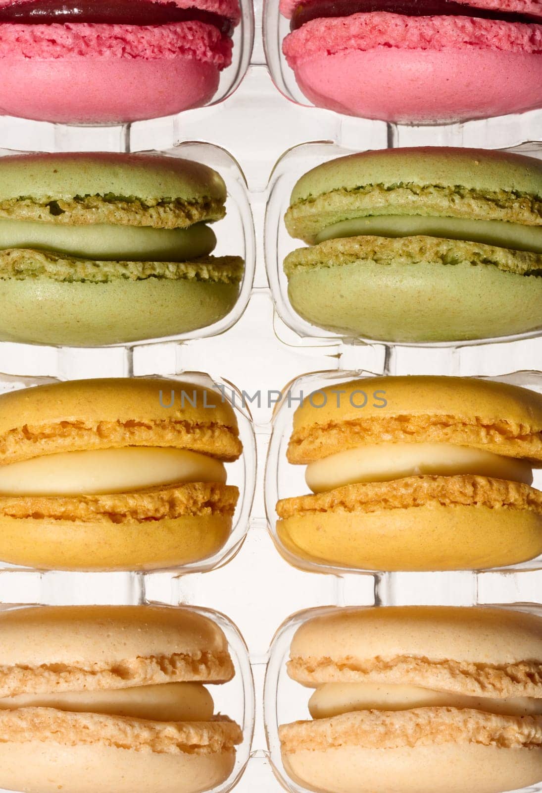 Macarons in plastic box on isolated background, top view