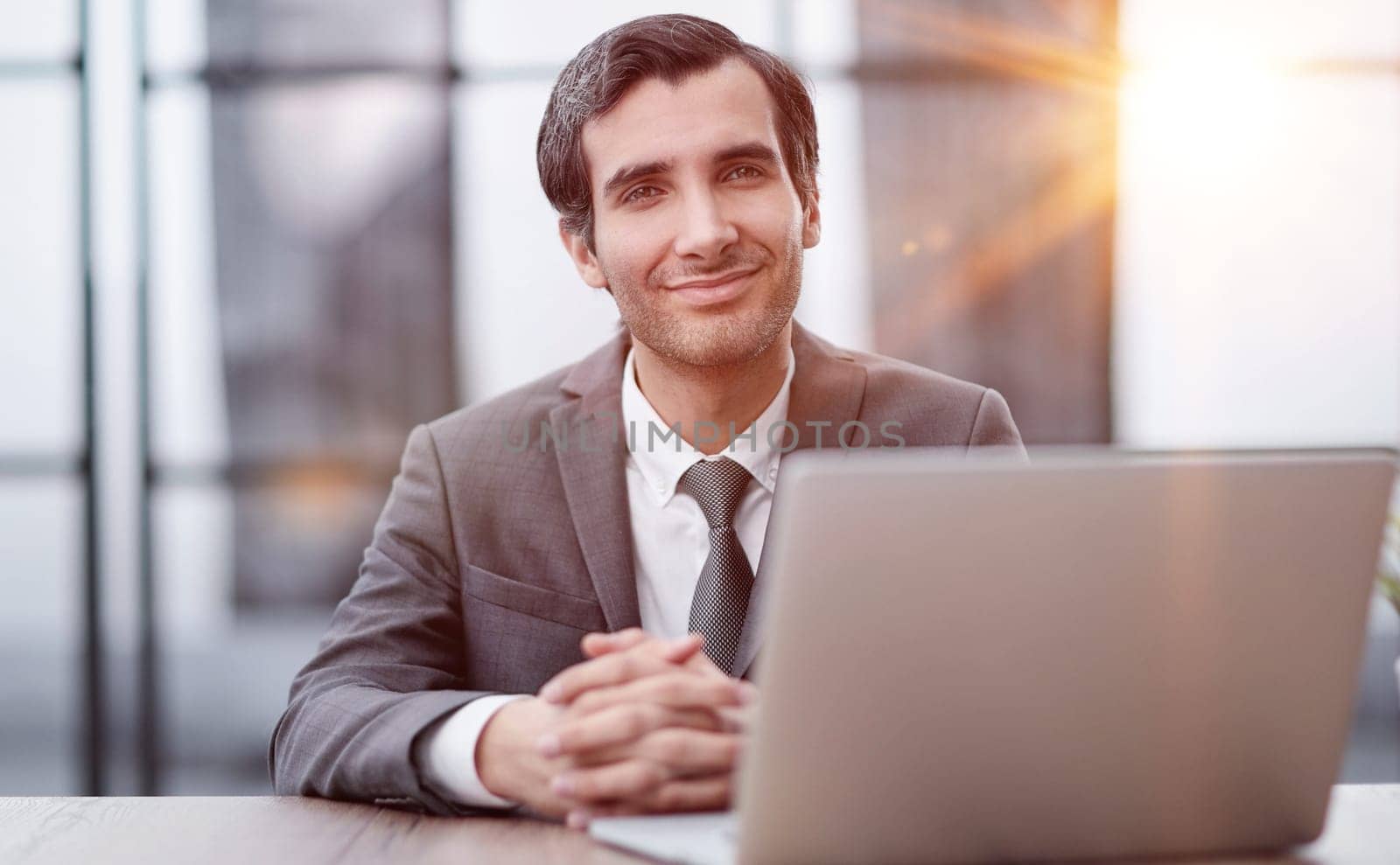 Young man using laptop and smiling at the office