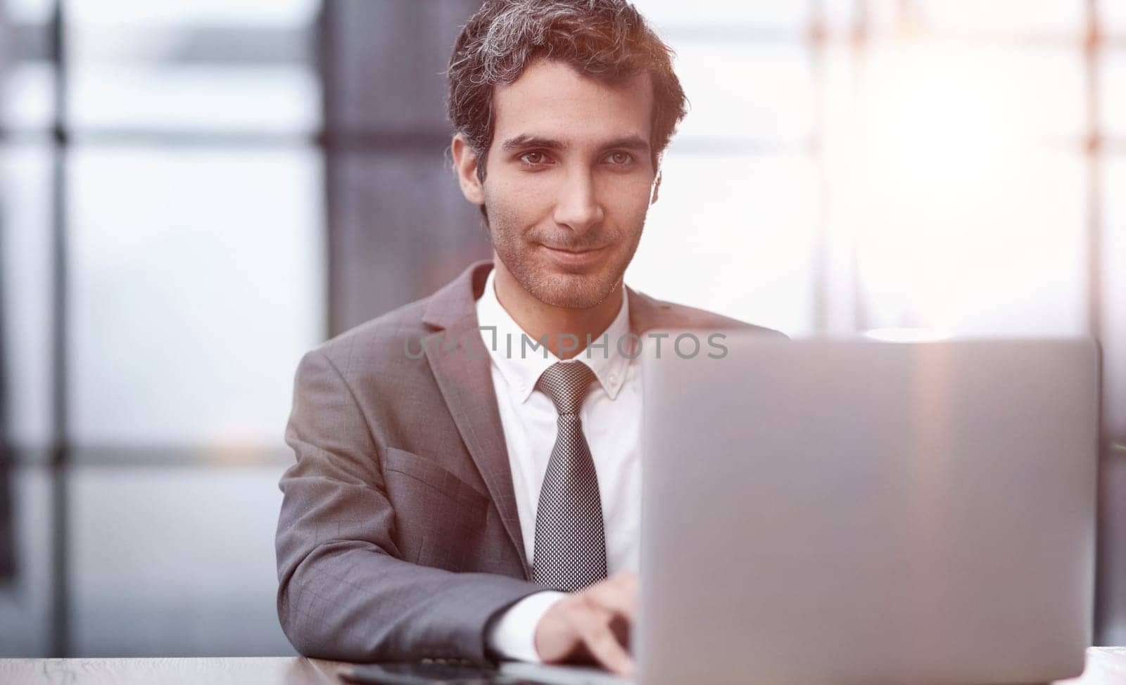 Successful businessman working inside office, man in business suit working at workplace with documents and laptop