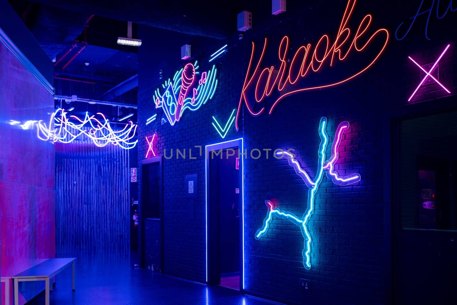 Glowing neon sign with word Karaoke and microphone mounted on brick wall, setting the scene for Karaoke night at illuminated arcade. Entertainment concept.