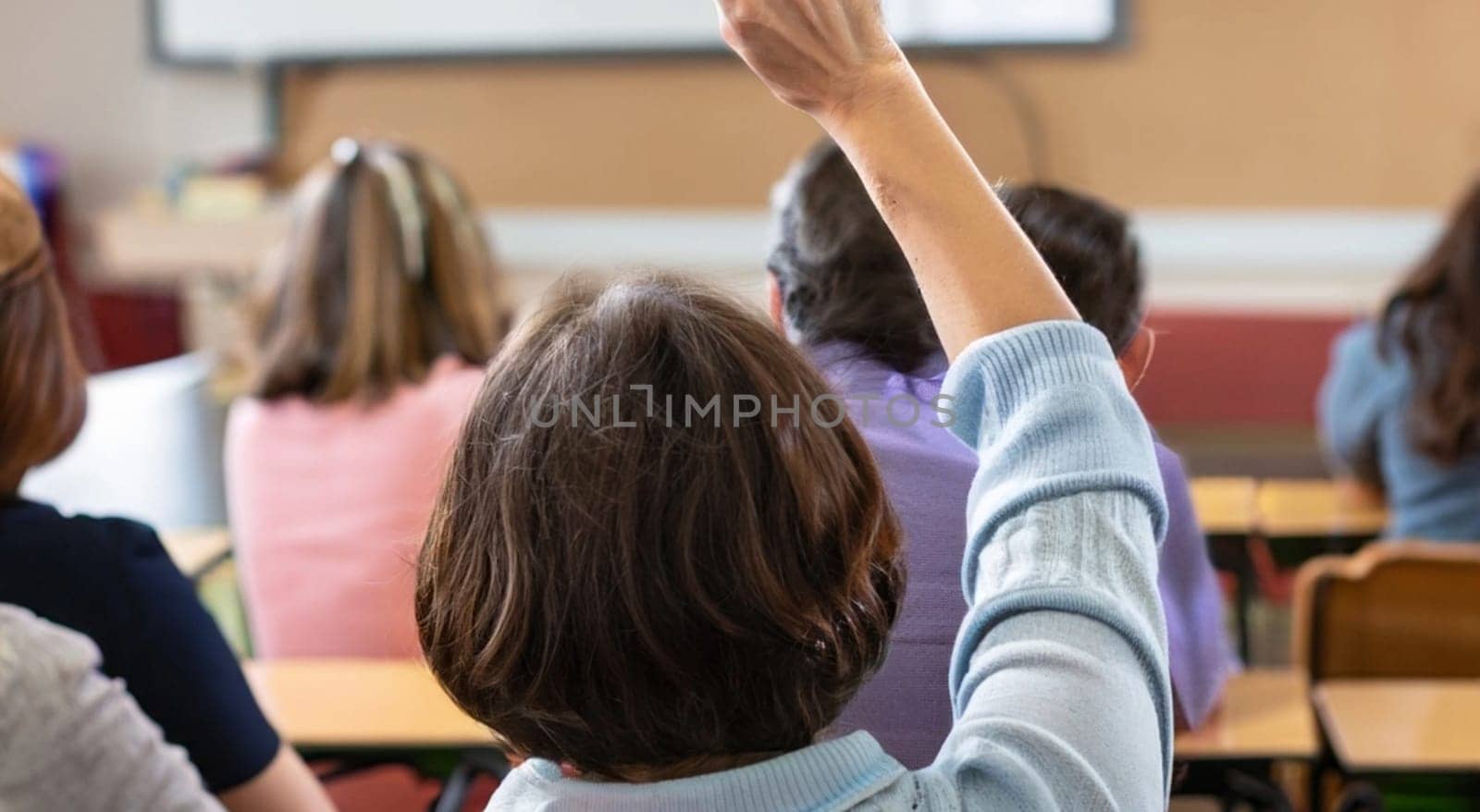 Back view of older student raising his hand to answer teacher's question during education training class. jpg ai image by Costin