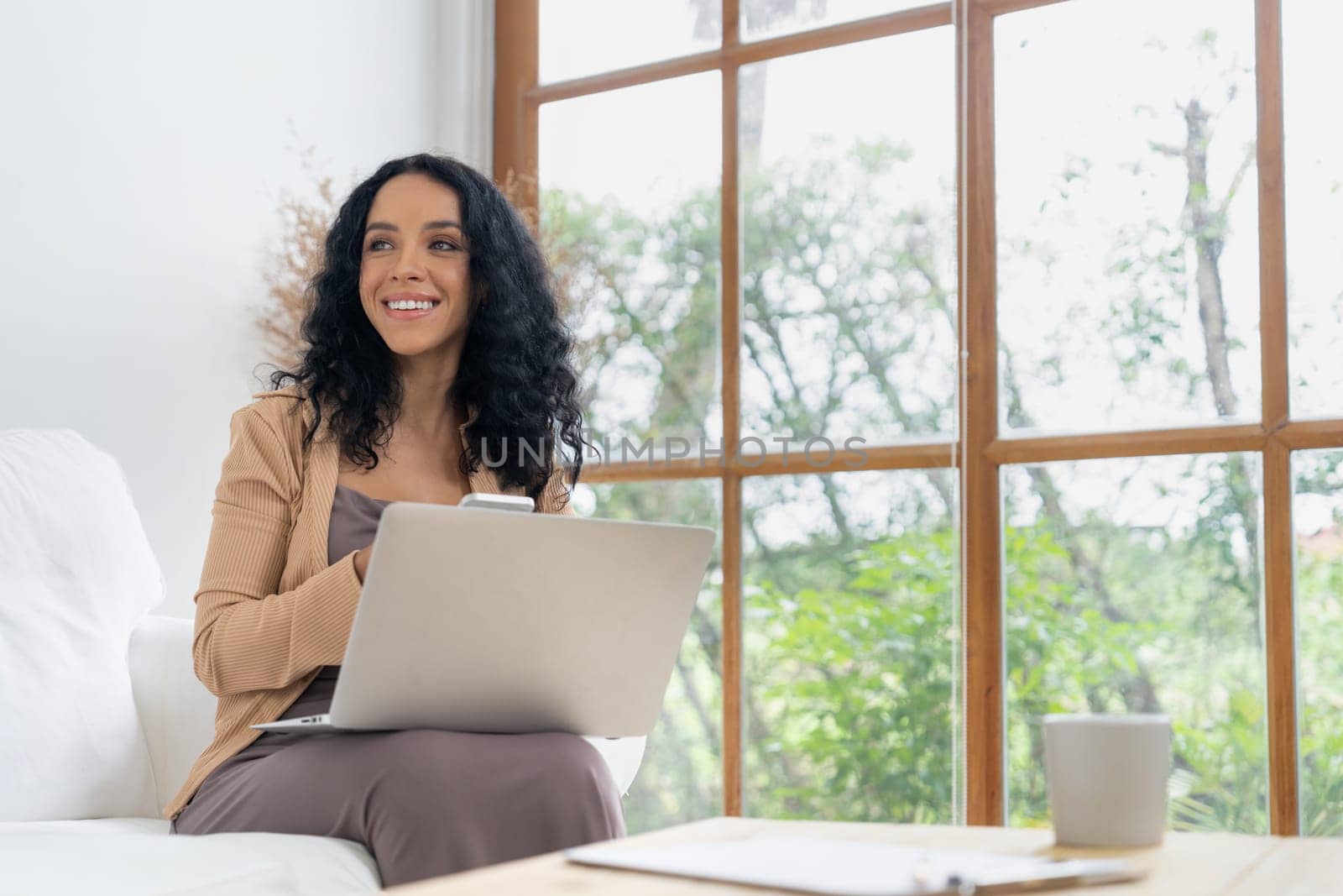 African-American woman using laptop computer for crucial work on internet. Secretary or online content writing working at home.