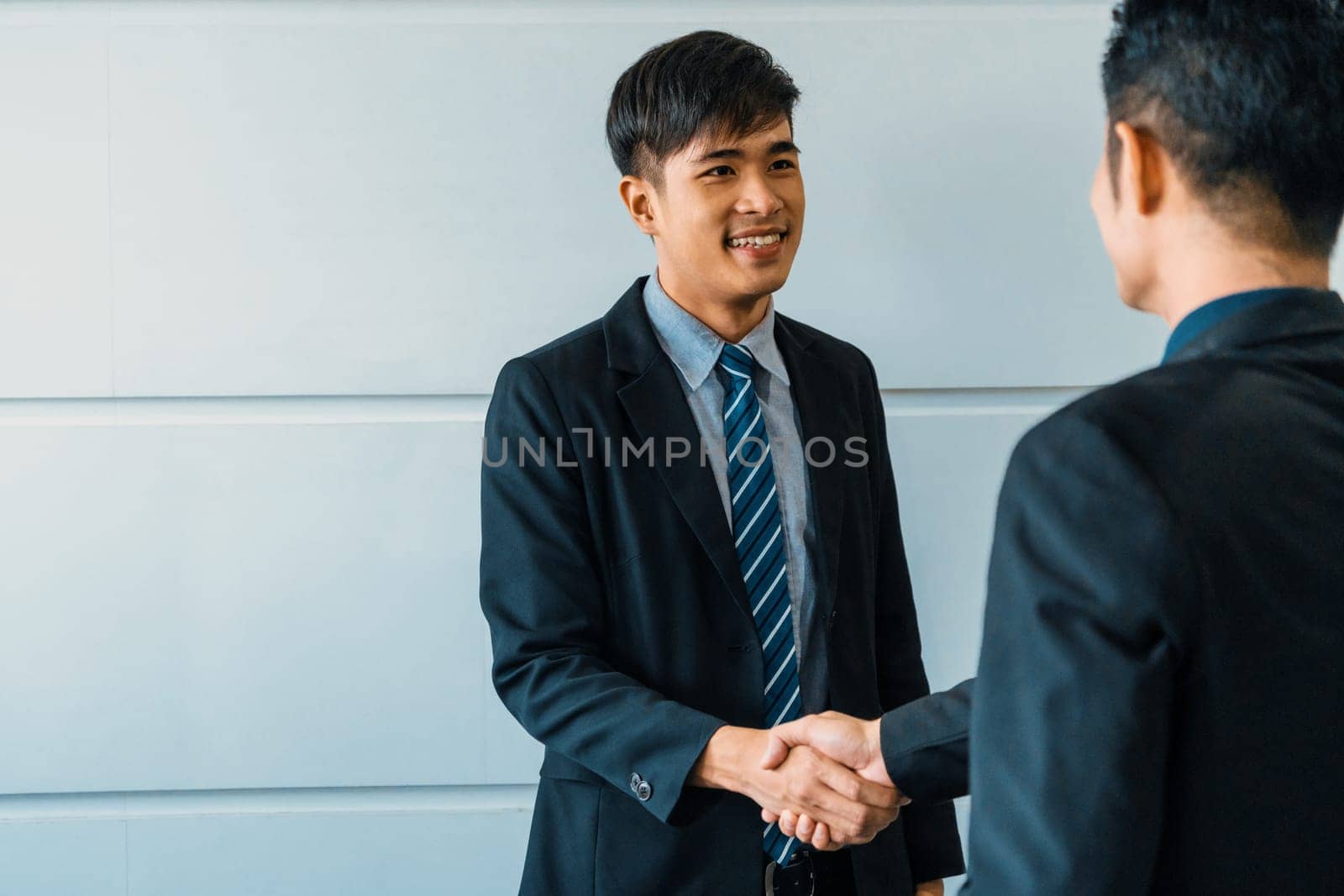 Business people agreement concept. Asian Businessman do handshake with another businessman in the office meeting room. uds