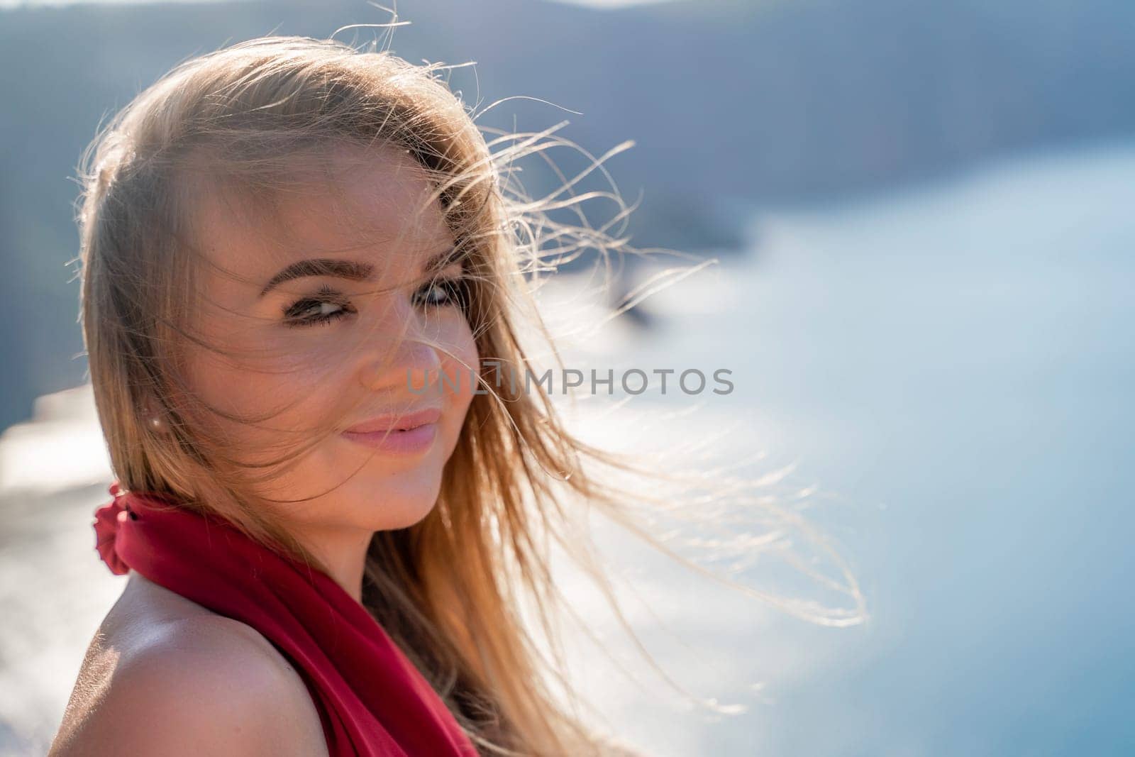 A woman in a red flying dress fluttering in the wind, against the backdrop of the sea. by Matiunina