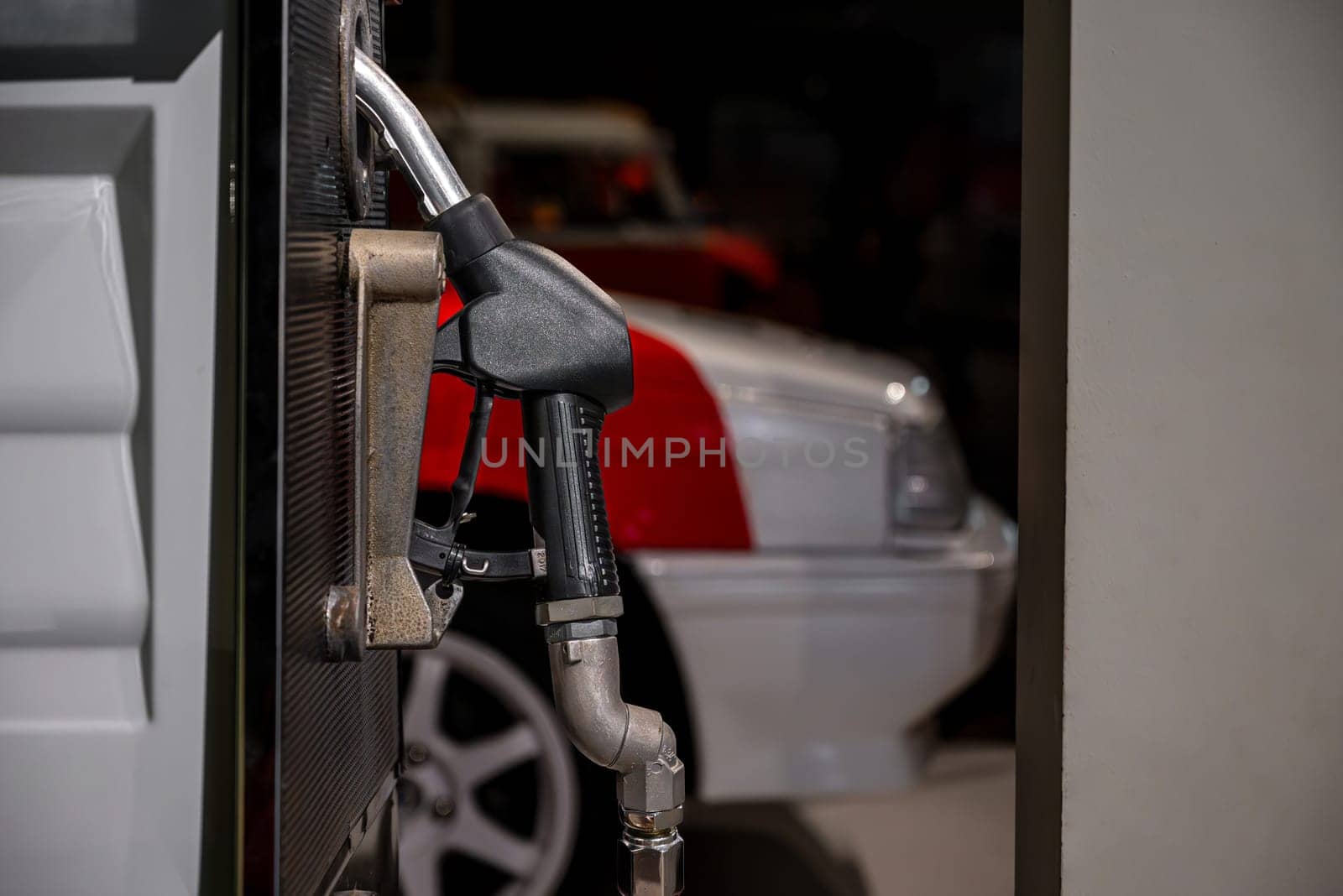 Old gasoline nozzle at the gas pump at the old gas station outside the city by Sonat