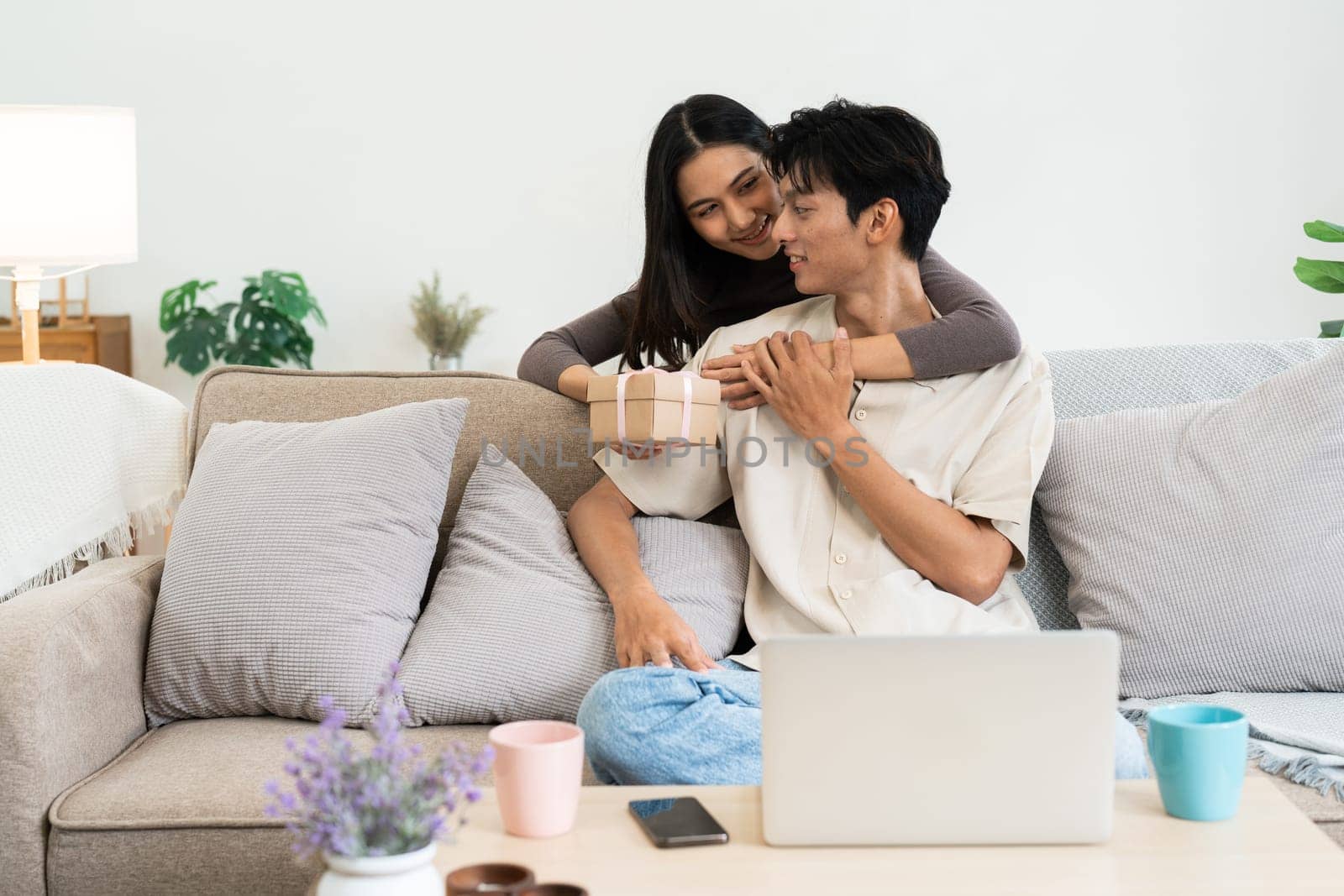 Happy young man holding Valentine gift, smiling and thanking his girlfriend for present by itchaznong