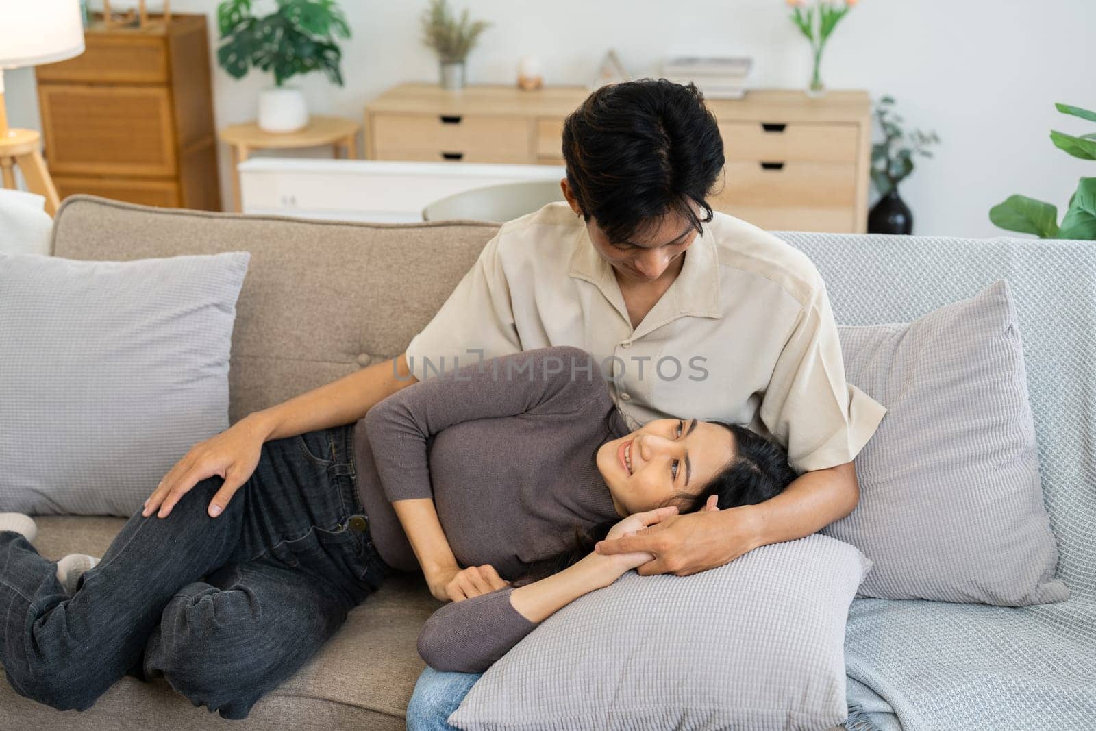 Happy young couple relax on sofa in living room together.Romantic day together. Valentine's Day concept by itchaznong