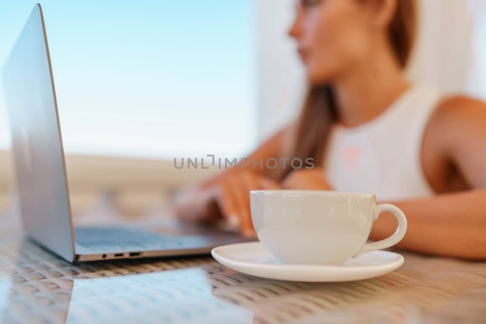 Woman coffee cafe laptop sea. Modern businessman in white uniform working on laptop in coffee shop. Woman sitting at a coffee shop with mobile phone drinking coffee. by Matiunina