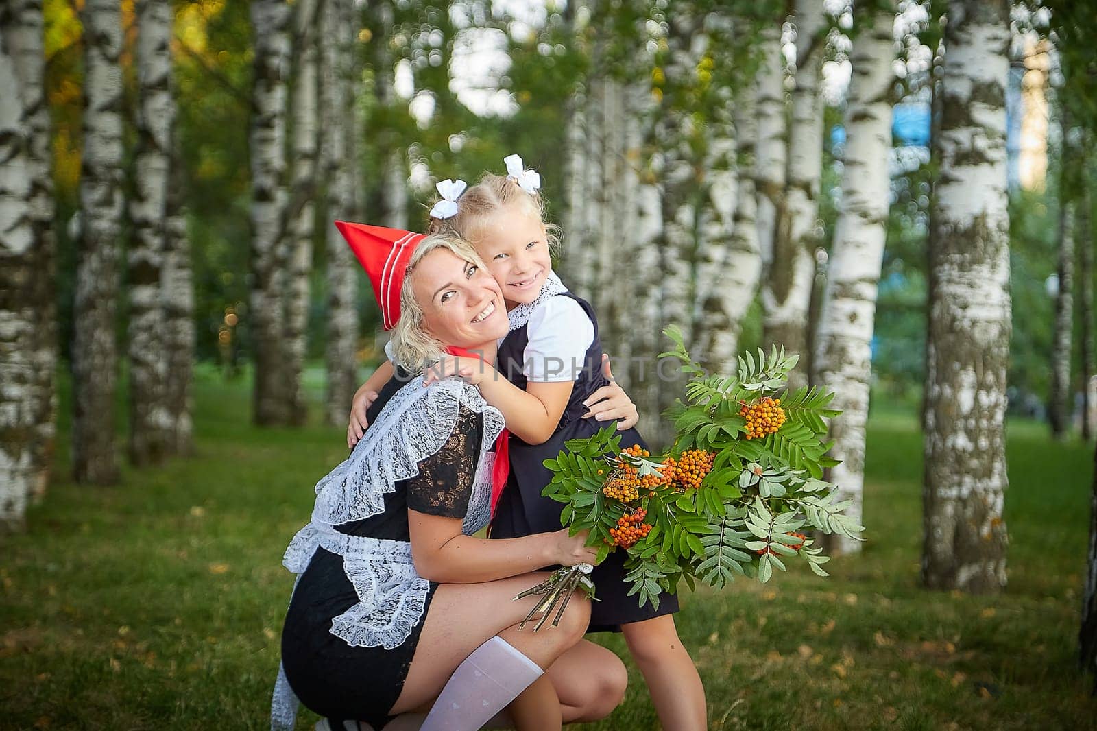 Young and adult schoolgirl on September 1 with flowers. Generations of schoolchildren of USSR and Russia. Female pioneer in red tie and October girl in modern uniform. Daughter and Mother having fun