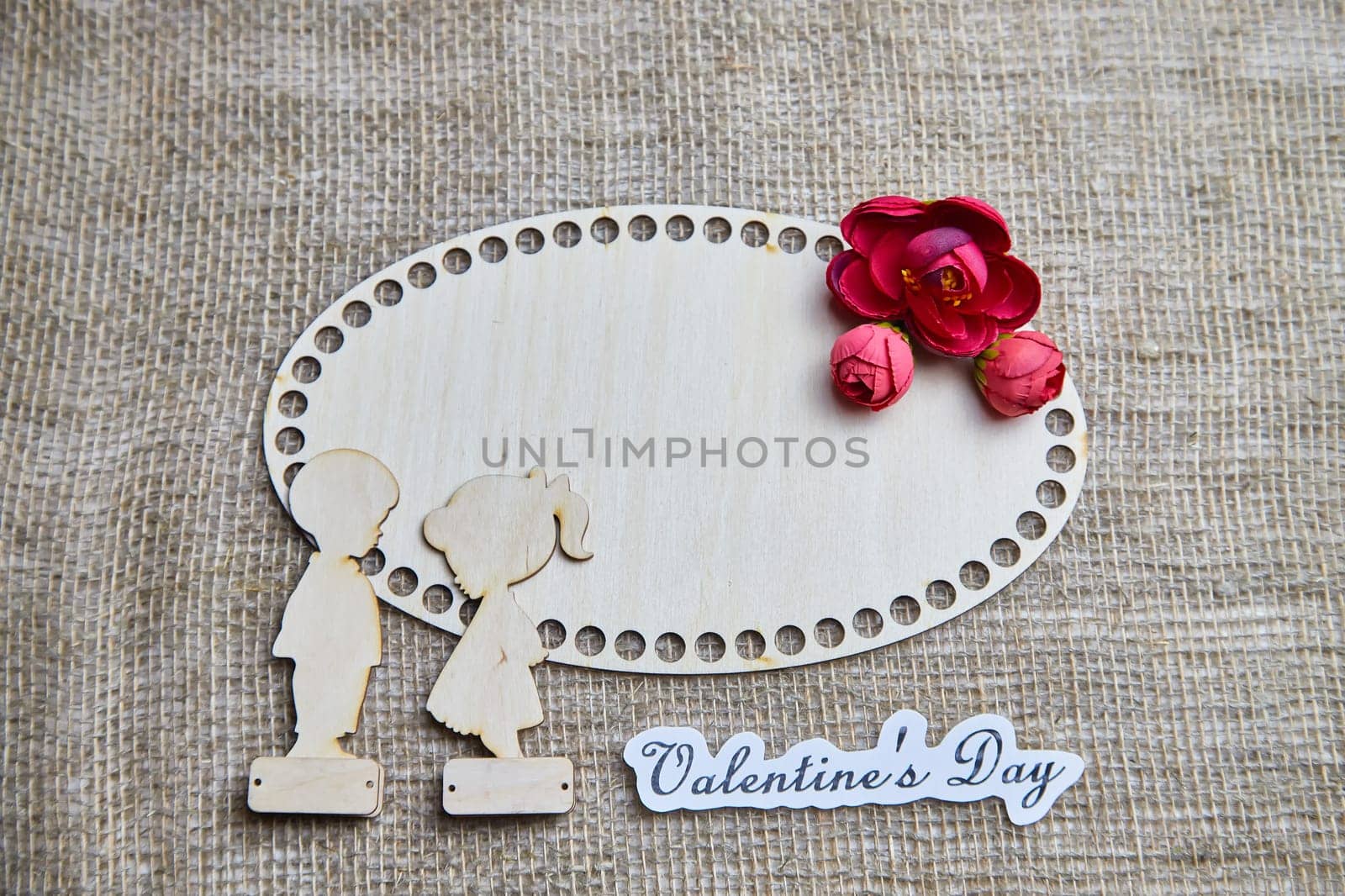 Wooden figurines of couple, inscription Valentine's Day, red flowers. Concept of holiday of love. Background, texture, frame, place for text, copy space