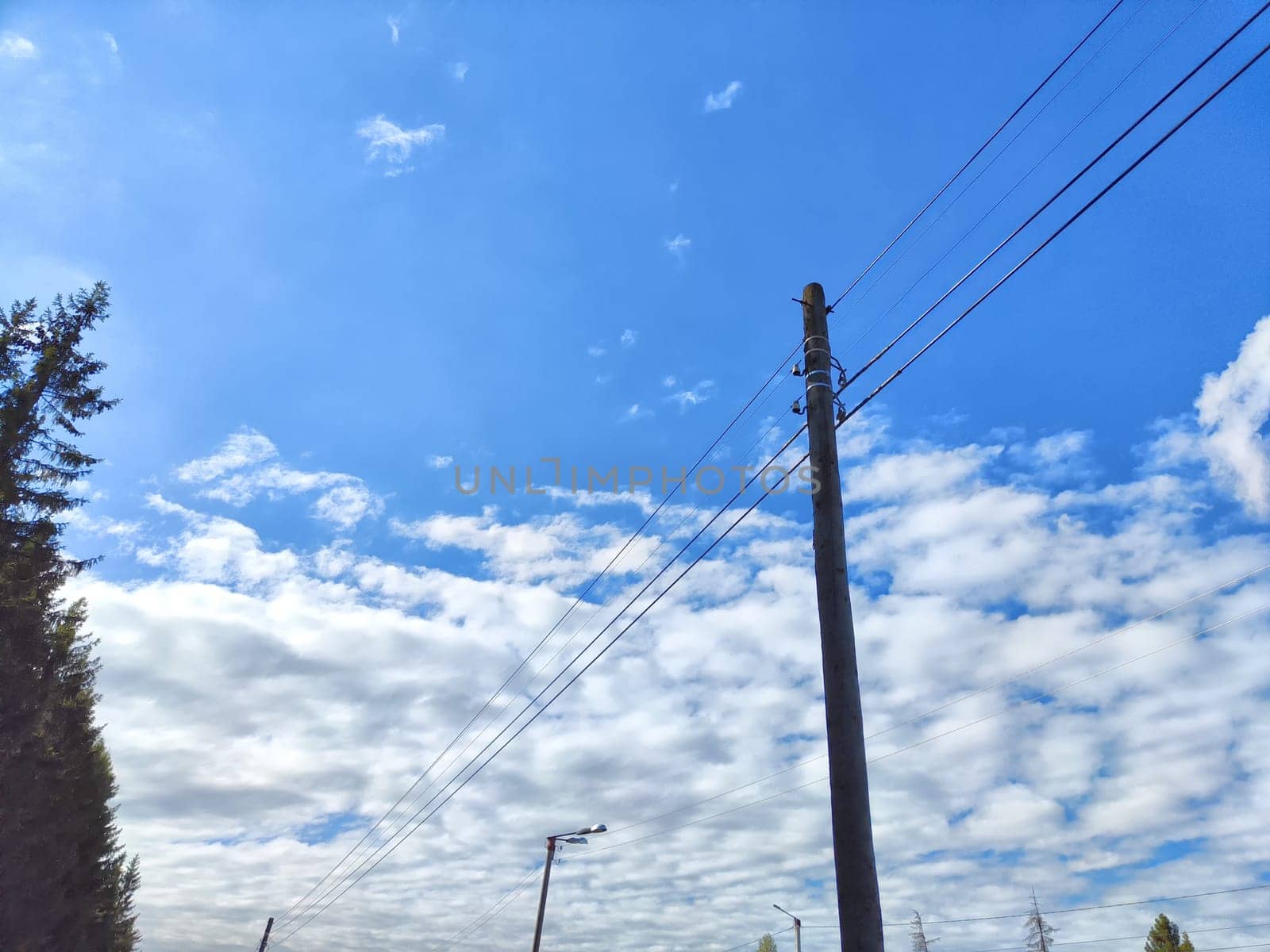 Old power line pole against blue sky in a nice sunny day
