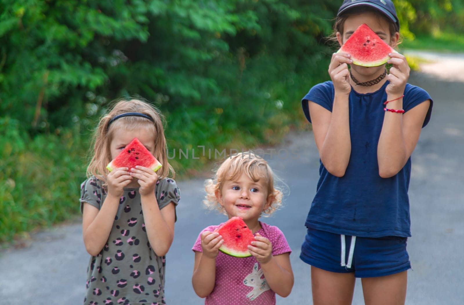 Children in the park eat watermelon. Selective focus. by yanadjana