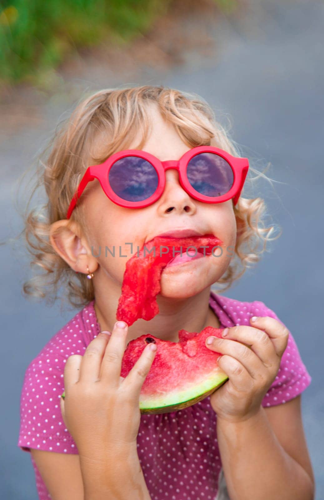 Child girl in the park eats watermelon. Selective focus. by yanadjana