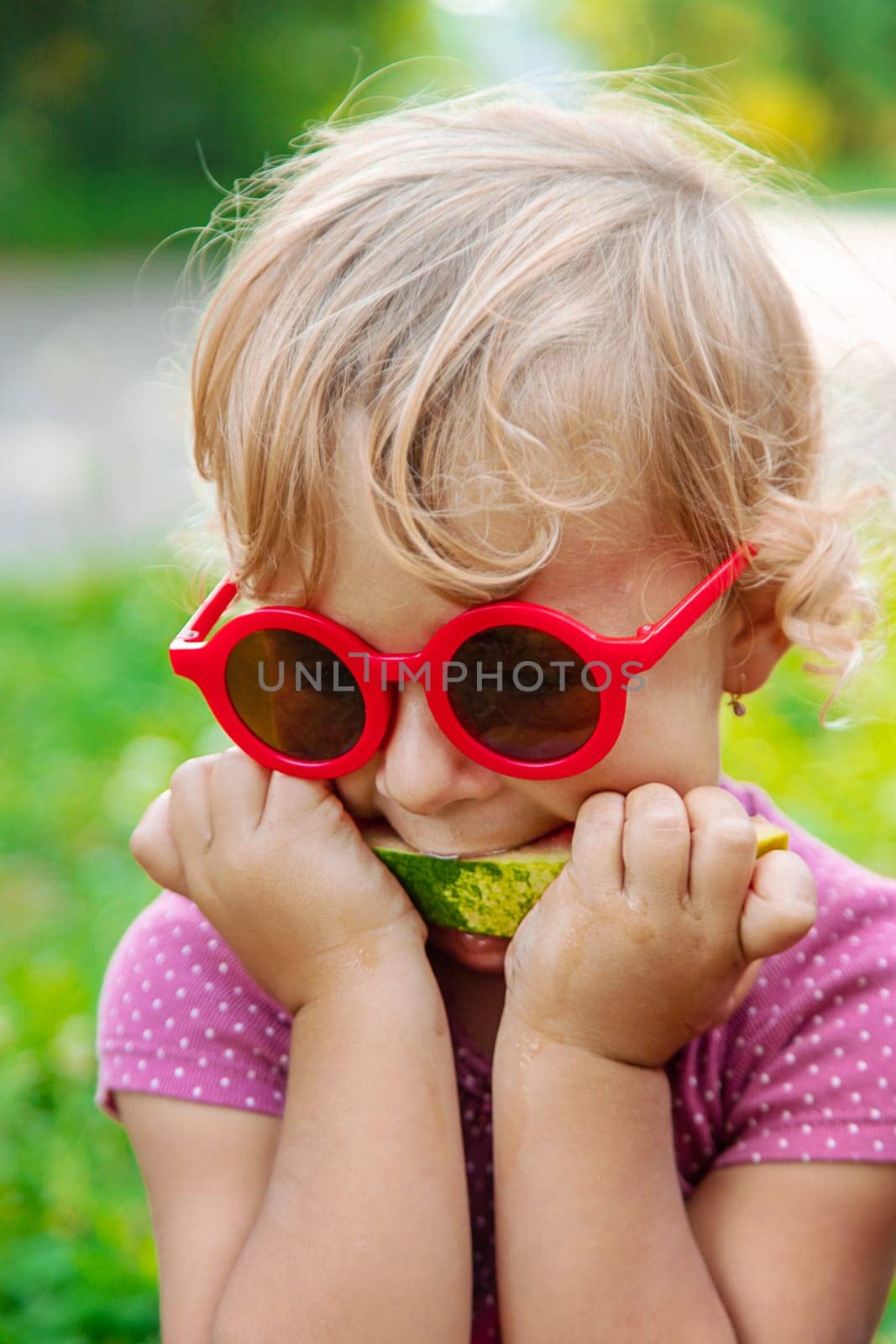 Child girl in the park eats watermelon. Selective focus. Food.