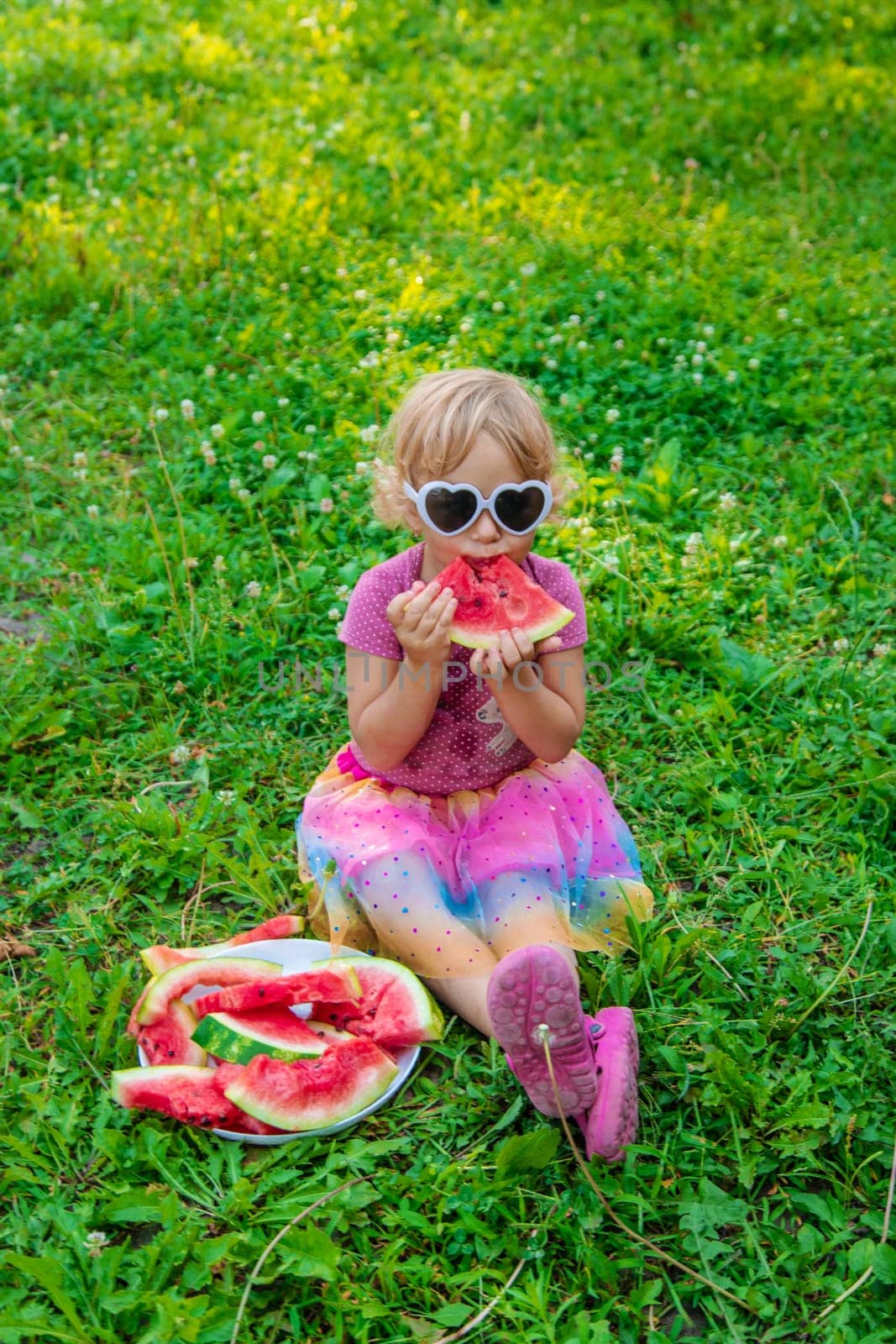 Child girl in the park eats watermelon. Selective focus. by yanadjana