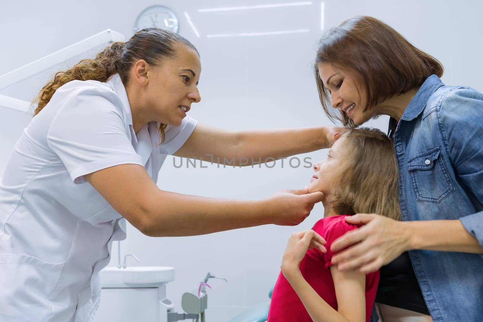 Mother and child girl in meeting with doctor orthodontist by VH-studio