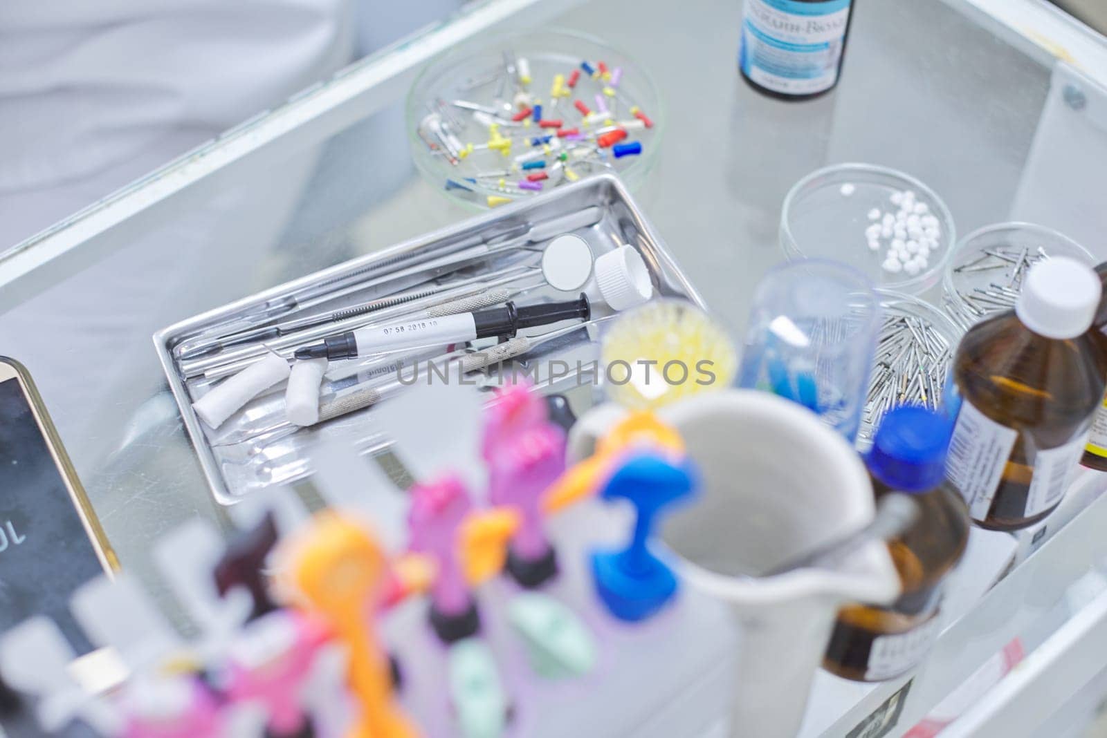 Close-up work at dentist desk, dental composite sealing materials instruments tools by VH-studio
