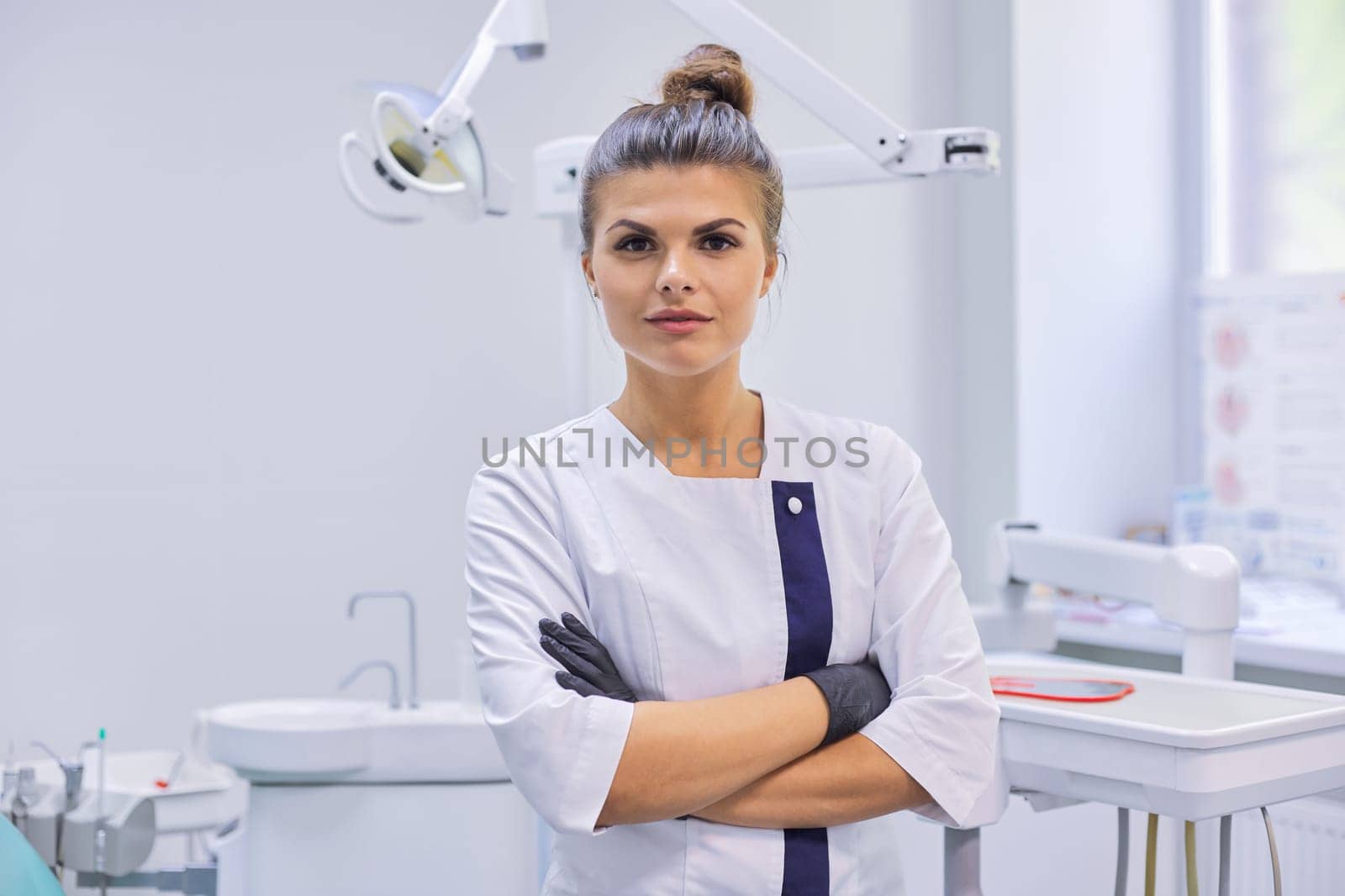 Portrait of young confident dentist doctor woman, female with arms crossed by VH-studio