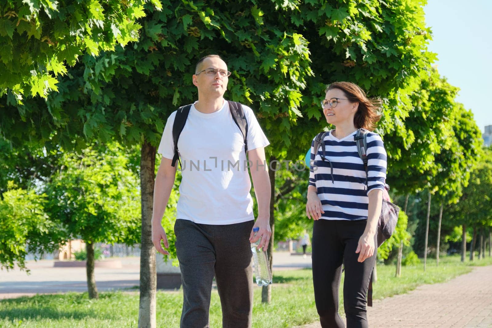 Mature couple walking and talking man and woman by VH-studio