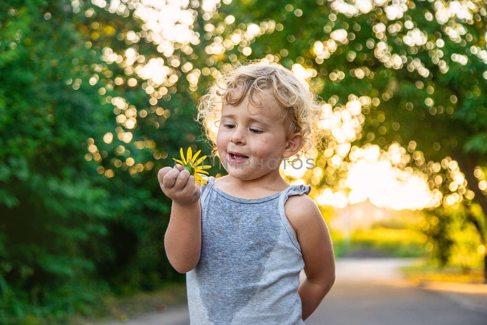 The child holds a flower in his hands. Selective focus. by yanadjana