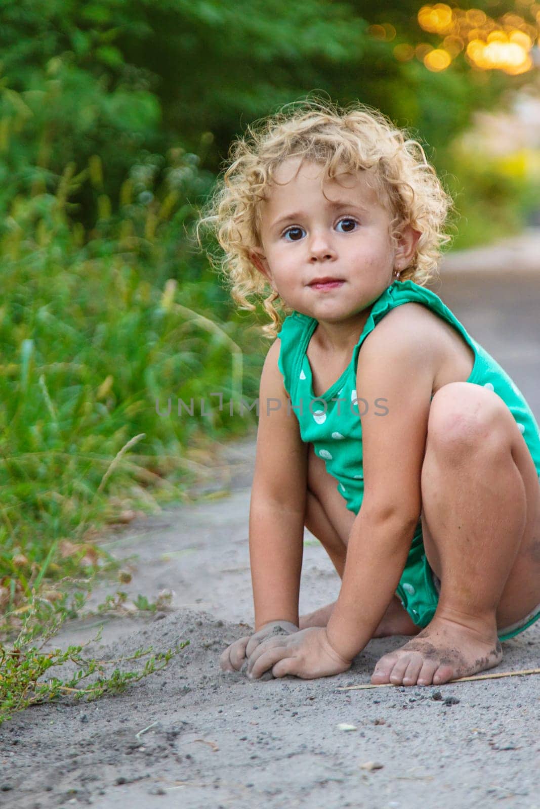 Children play with sand on the street. Selective focus. by yanadjana